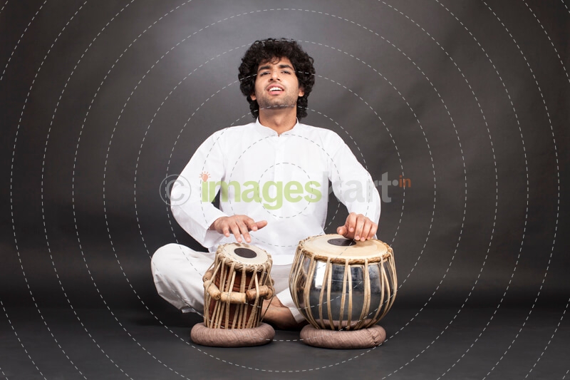 man playing tabla with grey background