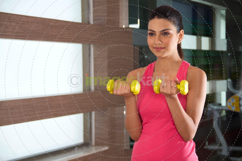young girl working out with yellow dumbbells
