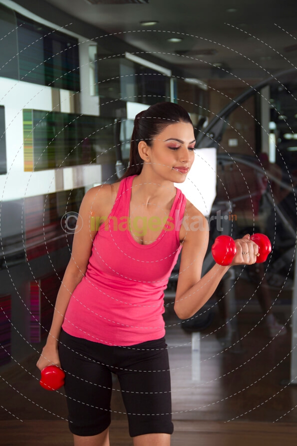 girl posing with red dumbbells 