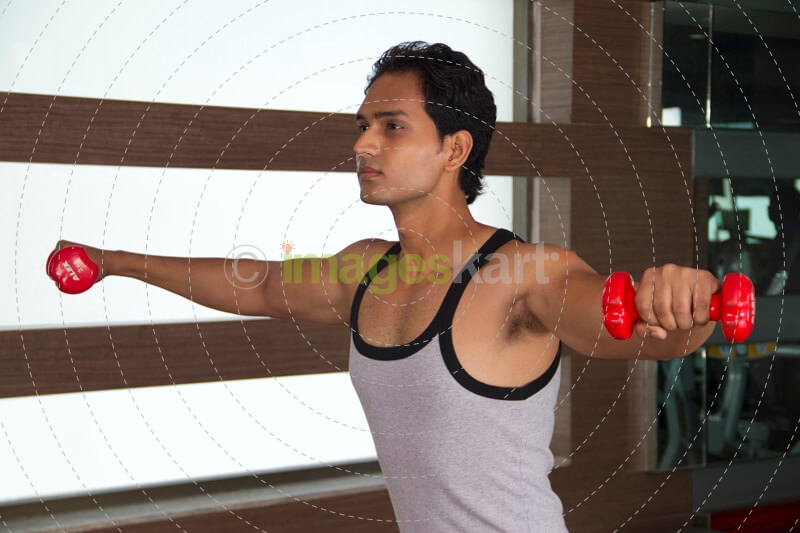 boy doing cardio at the gym with dumbbells