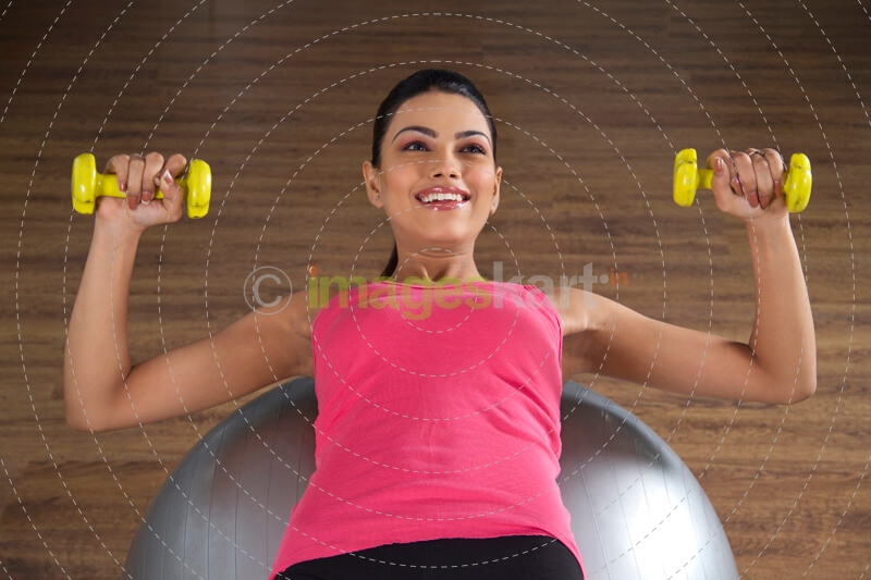 girl at the gym lying over a silver fitness ball