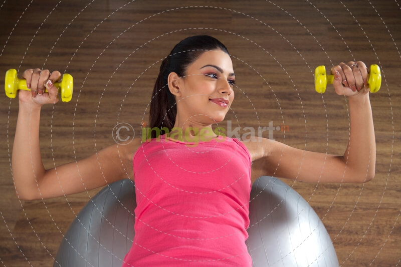 attractive girl with yellow coloured dumbbells
