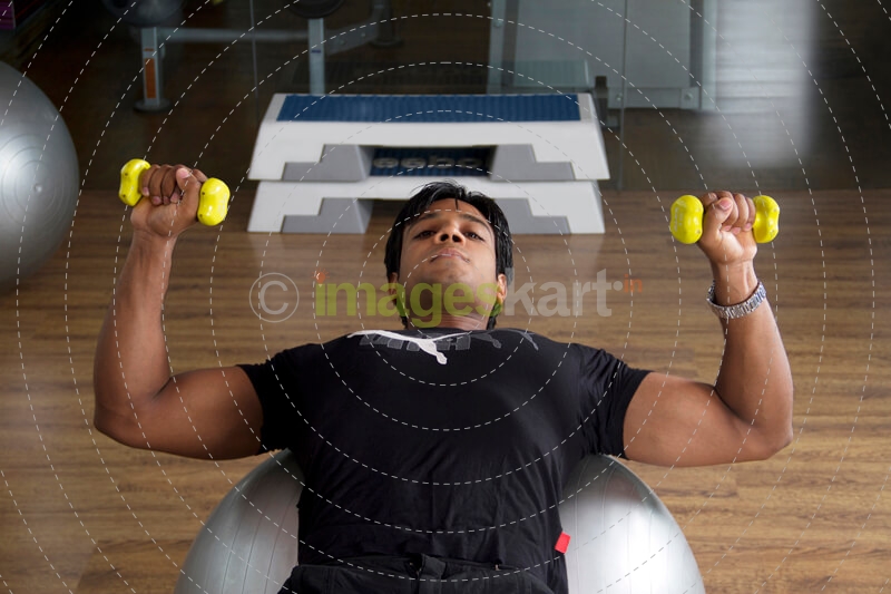 guy with good physique traing on a fitness ball