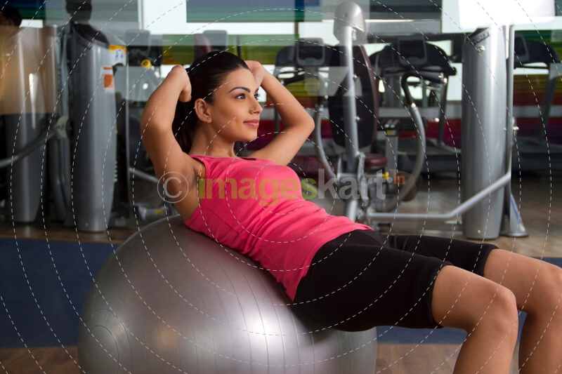 young woman with a silver ball against gym bakground