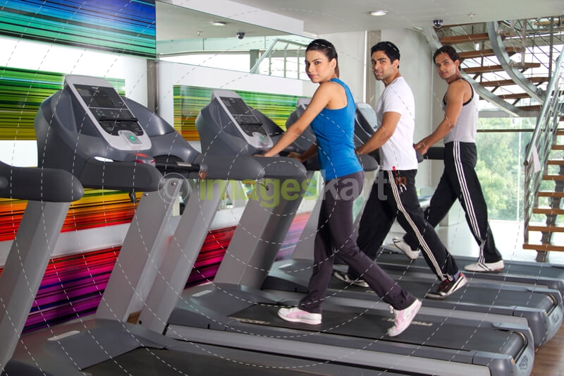 three youngsters looking at the camera while running on treadmills