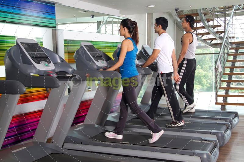 group of young teenagers running on treadmills