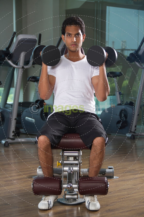 guy doing dumbbells with full efforts