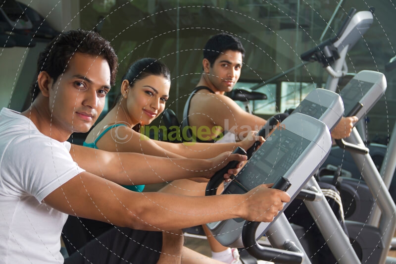 men and woman cycling at the gym