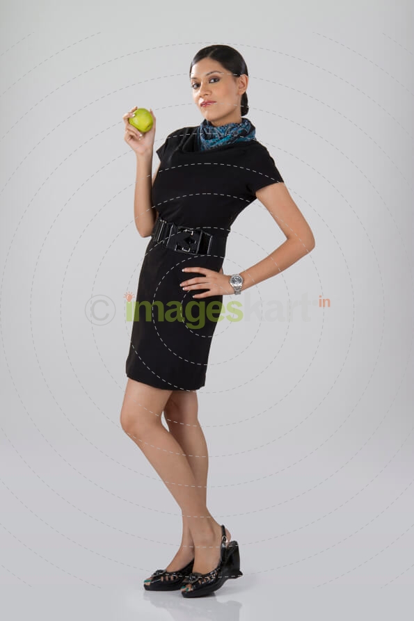 young air hostess holding an orange in hand