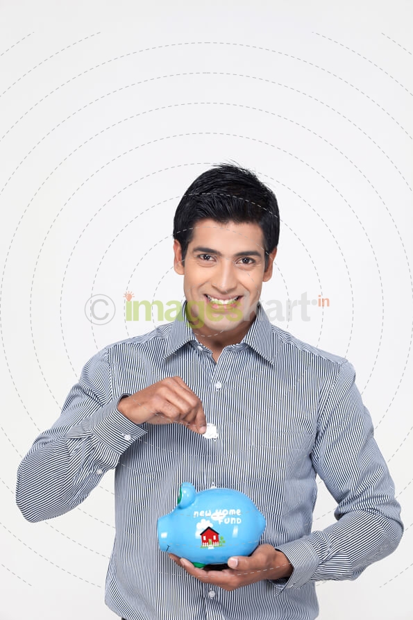 handsome portrait of a young man with a piggy bank