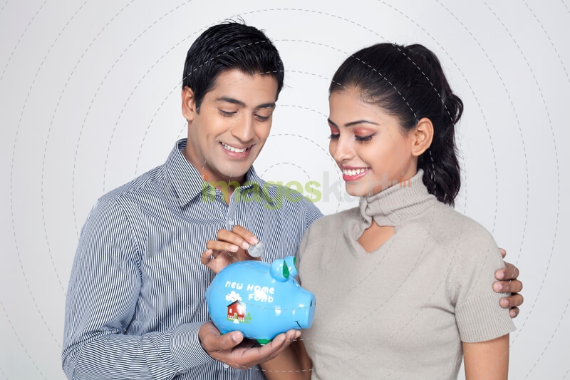 woman dropping a coin in the piggy bank