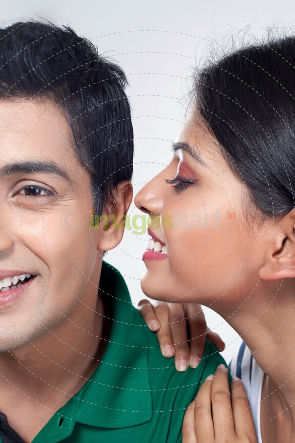 girl whispering in boys ear