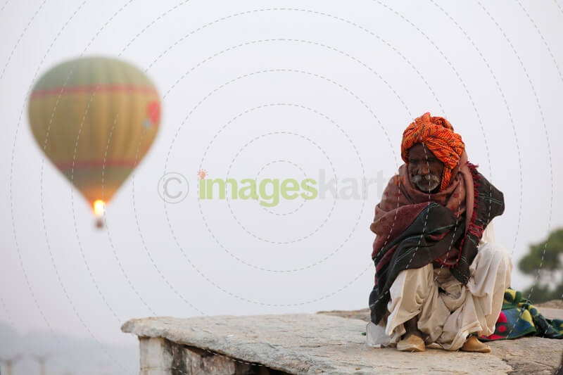 balloons flying over an idle old man