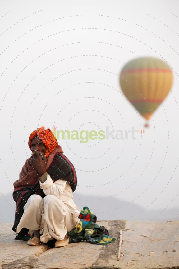 balloons flying over an idle old man