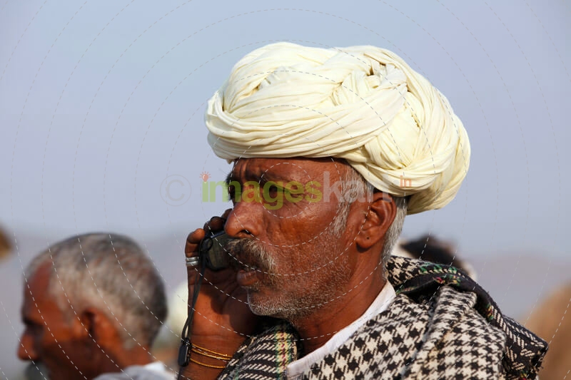 rural mean wearing turban talking on phone 