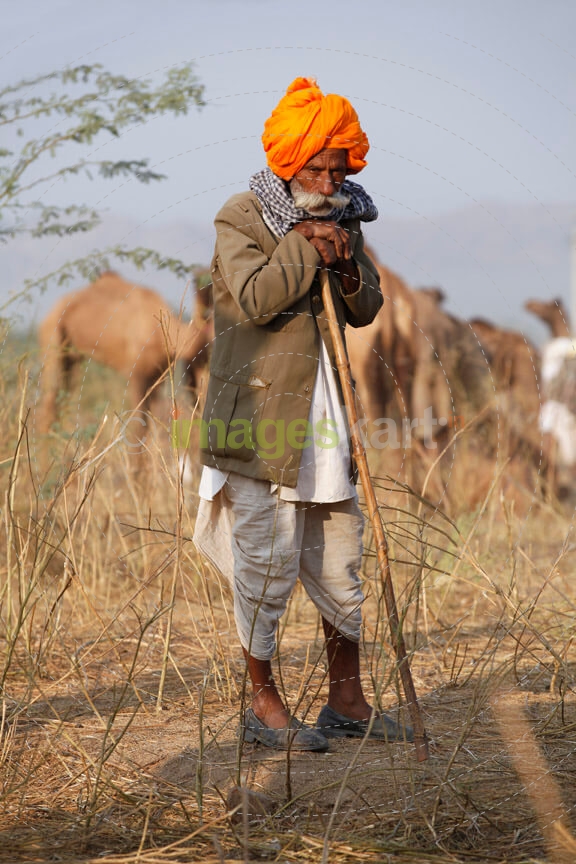rural man standing with a laathi 