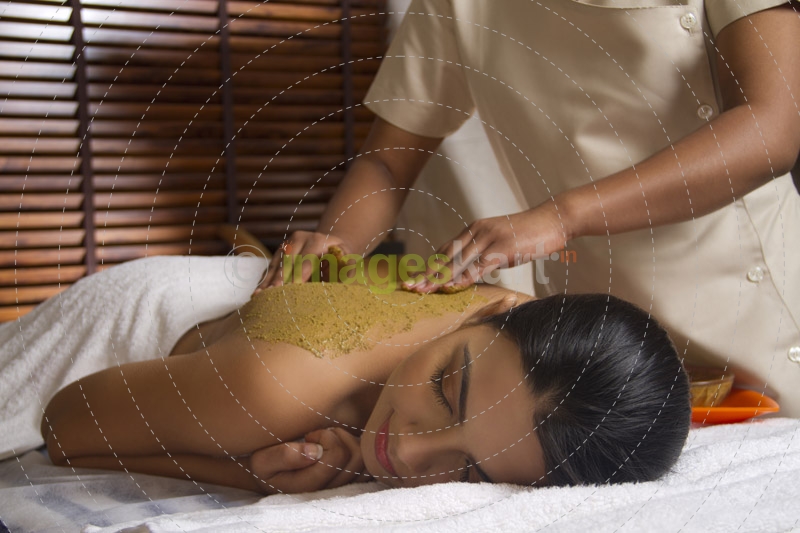 therapist applying ayurvedic  pack with both hands 