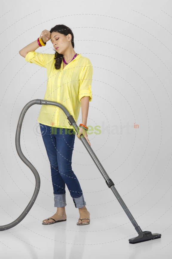 woman tired after cleaning with vacuum cleaner 