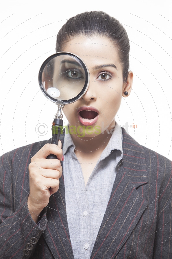 girl surprised while looking through magnifying glass 