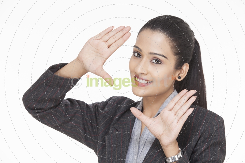 beautiful young businesswoman posing while framing with hands