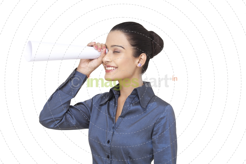 girl smiling while looking through rolled paper sheet