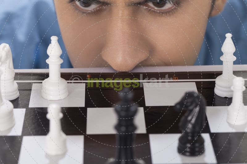 man staring at chess pawns 