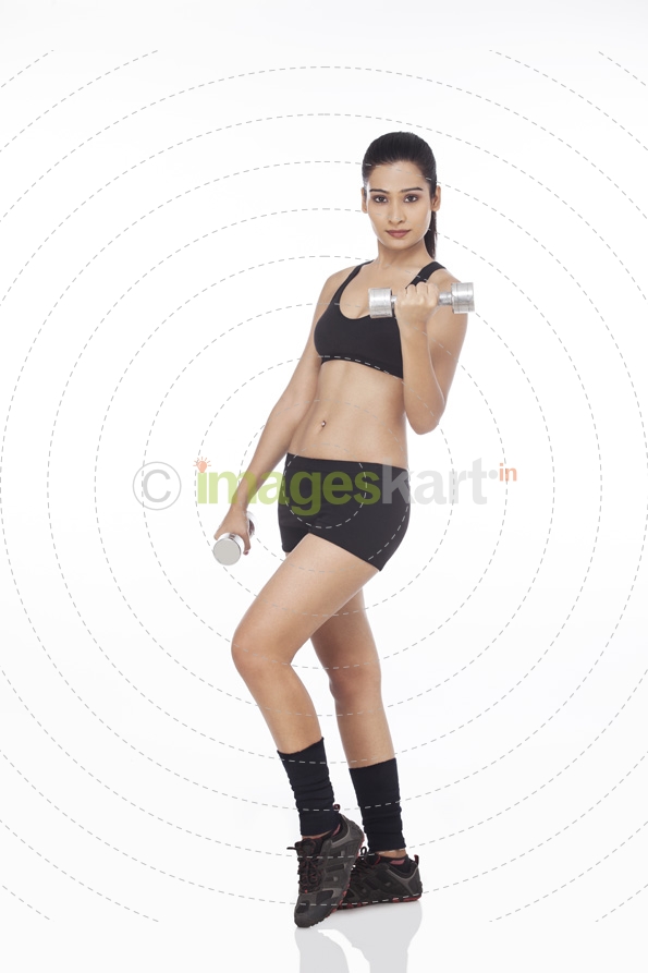 girl posing in style with metal dumbbells 