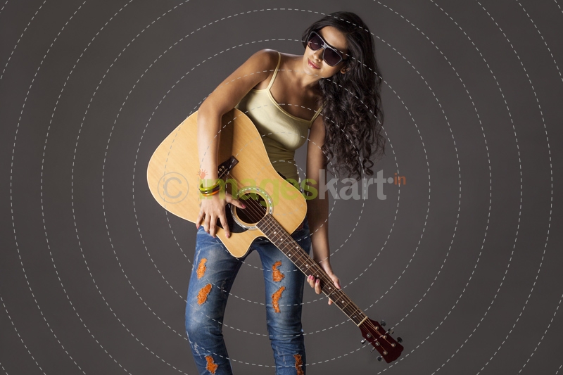Girl wearing sunglasses and playing guitar