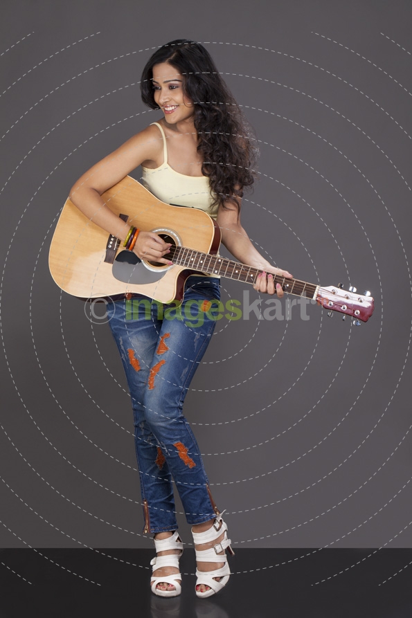 girl looking away and playing guitar