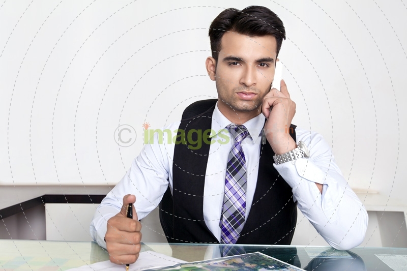 man at his office desk and talking on phone 