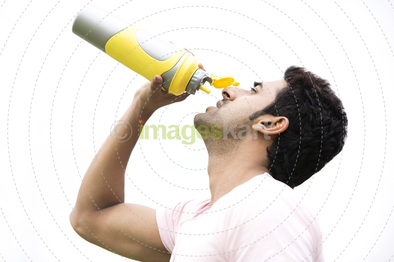 man drinking energy drink from bottle 