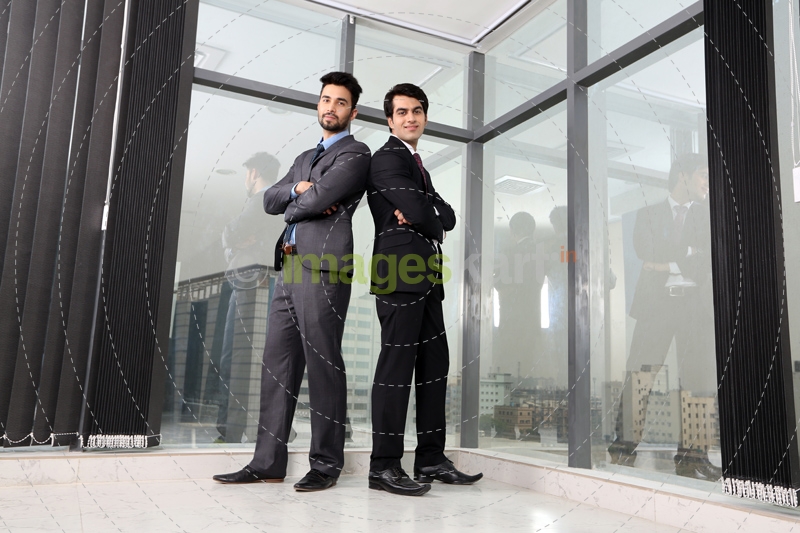 men in formals standing back to back