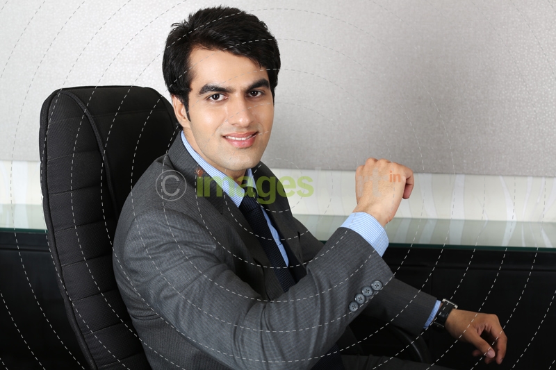 man in formals sitting on his chair 