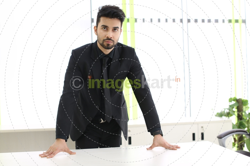 man in formal wear standing in his office cabin 