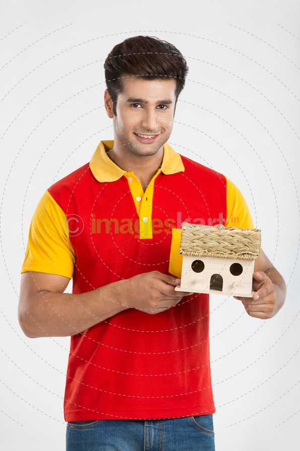 man posing with smile while holding miniature with both hands 