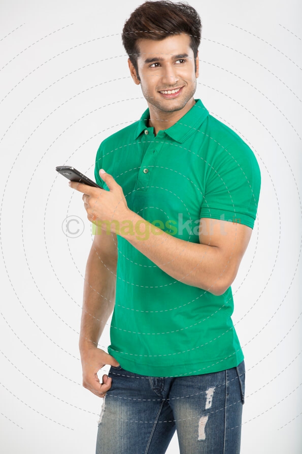 man smiling while posing with mobile phone