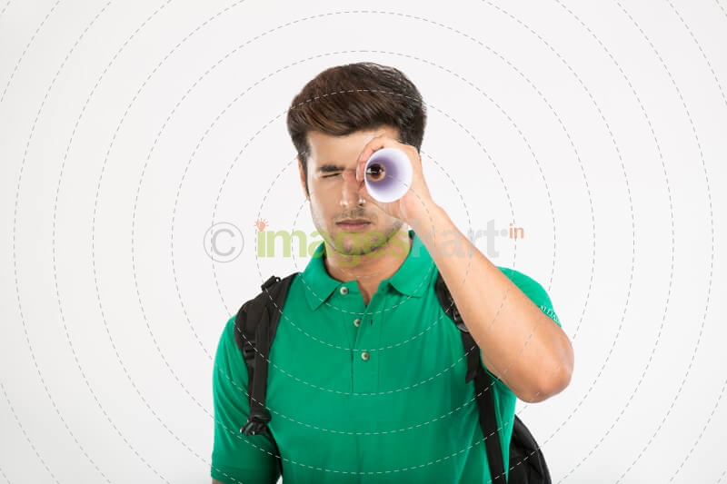 college boy looking through rolled sheet of paper 