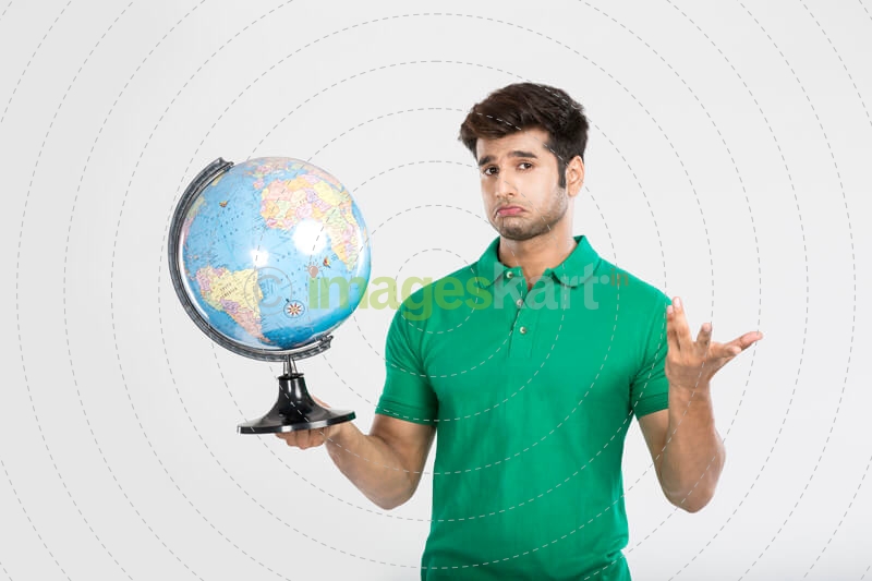 man confused while holding a desktop globe  