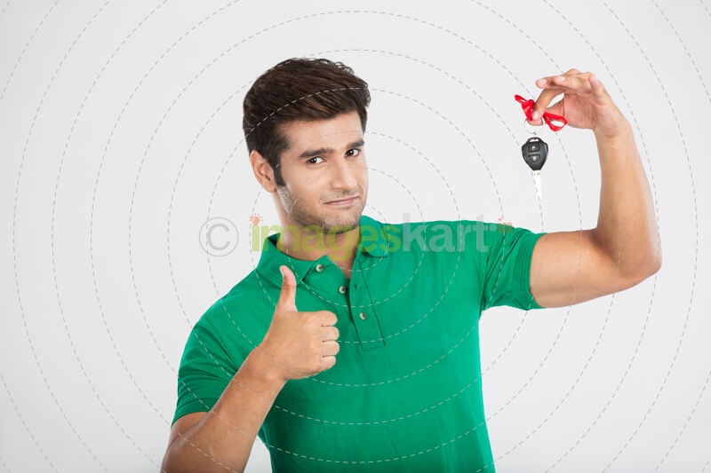 man showing thumbs up while holding a car key 