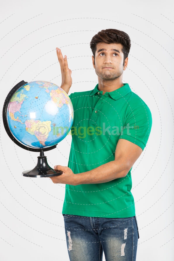 man confused and holding desktop globe 