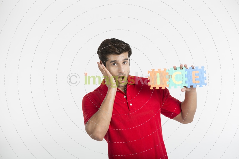 guy posing in surprise while holding a jigsaw puzzle