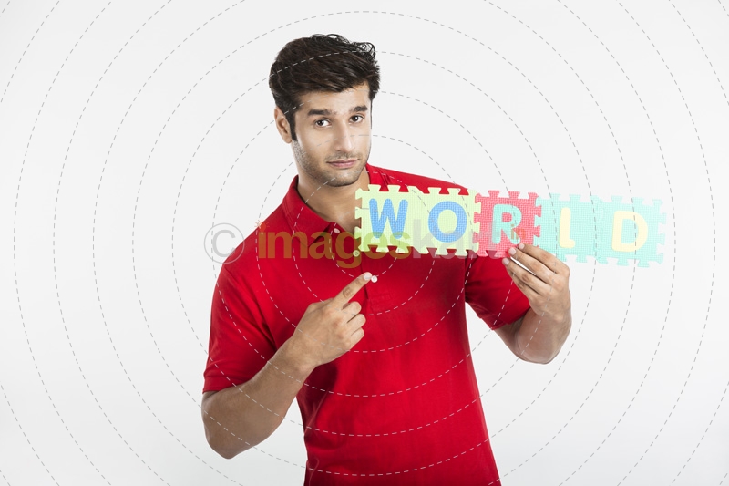 guy pointing towards letter made from jigsaw puzzle 