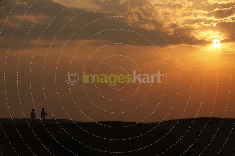 silhouette of men standing against sun