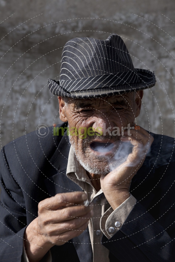 old ladakhi man having cigarette puff 