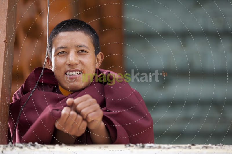 monk smiling and posing at the ladakh monastery