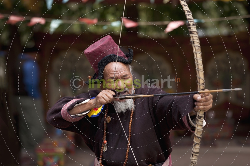 old ladakhi man practicing archery 