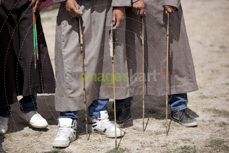 below waist picture of ladakhi children playing with arrow 