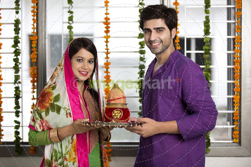 couple holding pooja thali and kalash 