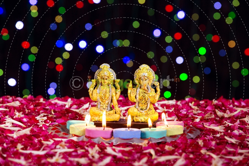 lord ganesha and luxmi statues with diyas in front