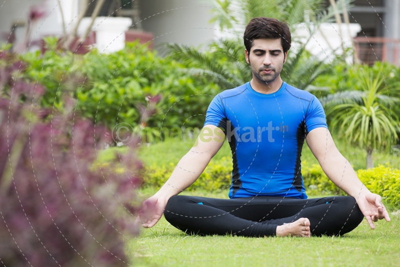boy doing meditation in park 